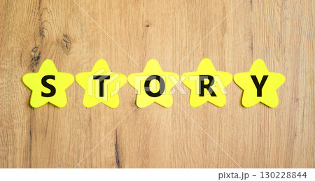 Story symbol. Concept word Story on beautiful yellow paper stars. Beautiful wooden table wooden background. Business lifestyle story concept. Copy space. 130228844