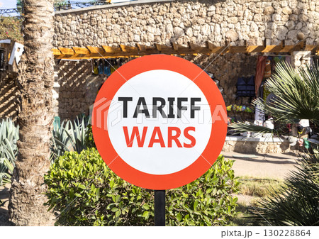 Trade tariff wars symbol. Concept word Tariff wars on beautiful red and white road sign. Beautiful palm tree and market background. Business trade tariff wars concept concept. Copy space. 130228864