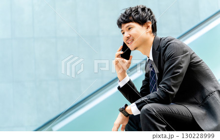 スマートフォンで通話をする男性ビジネスマン スマートフォンで通話をする男性ビジネスマン 130228999