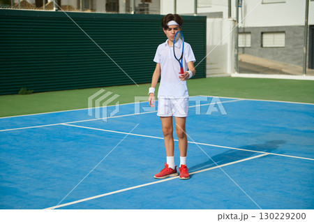 Young Tennis Player in Action on a Bright Outdoor Court 130229200