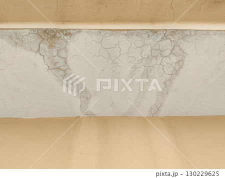 Close up of damaged ceiling with cracks and water stains on aged surface 130229625