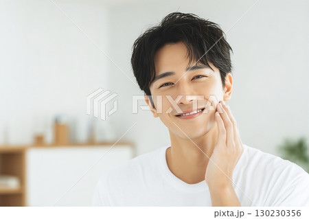 肌に手を添えて笑顔を見せる清潔感のある若い日本人男性 130230356