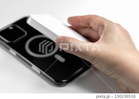 Hand holding phone and external magnetic battery 130230510