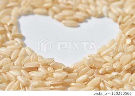 Heart shape made of uncooked brown rice grains on white background symbolizing Heart shape made of uncooked brown rice grains on white background symbolizing 130230566