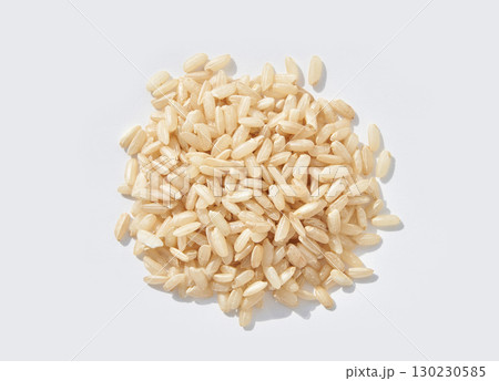 Brown jasmine rice uncooked grains scattered on white background, close up top 130230585