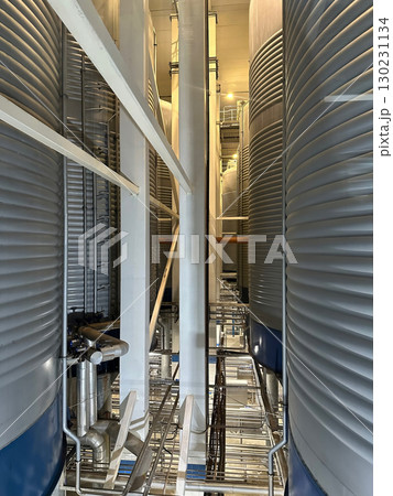 Fragment of an industrial building with many tanks and pipes. 130231134