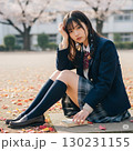 桜の木の下で座っている女子高生 130231155