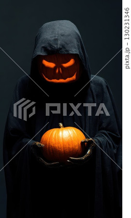 Creepy figure with glowing pumpkin at night 130231346