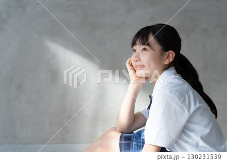 笑顔で頬杖をつく女子学生の横顔 130231539