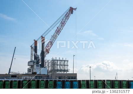 Building crane loader outside. Look above from backyard of an house blue sky and sun light in the city. Building crane loader outside. Look above from backyard of an house blue sky and sun light in the city. 130231577