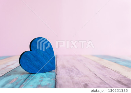 Blue wood heart on the wood colorful background with space for text. Concept with love sign for card. Blue wood heart on the wood colorful background with space for text. Concept with love sign for card. 130231586