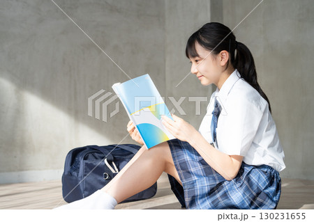笑顔で教材を読む女子学生の横顔 笑顔で教材を読む女子学生の横顔 130231655
