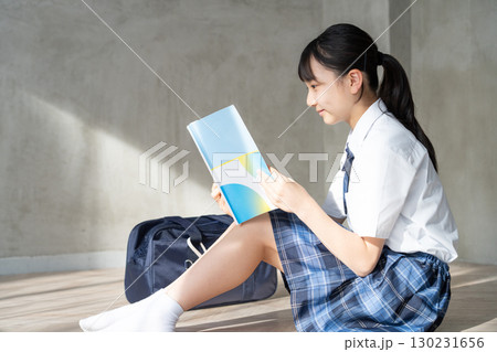 笑顔で教材を読む女子学生の横顔 笑顔で教材を読む女子学生の横顔 130231656