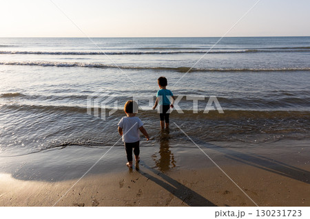 砂浜で海を眺める二人の子供 130231723