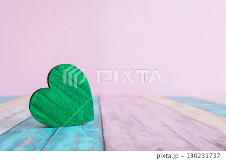 Beautiful green wood heart on the wood colorful background with space for text. Concept with love sign for card. 130231737
