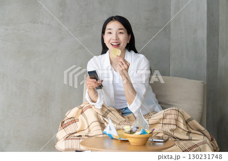ソファでテレビを楽しむ大人の女性 ソファでテレビを楽しむ大人の女性 130231748