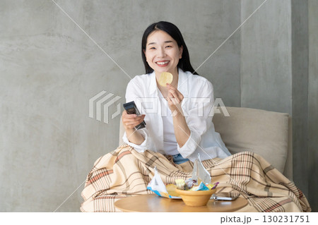 ソファでテレビを楽しむ大人の女性 130231751