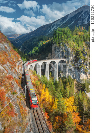 Aerial view of modern red train on Landwasser viaduct Aerial view of modern red train on Landwasser viaduct 130231786