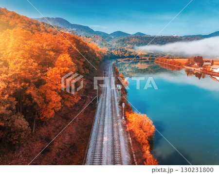 Aerial view of railroad, alpine lake, autumn forest at sunrise Aerial view of railroad, alpine lake, autumn forest at sunrise 130231800