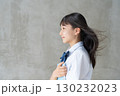 髪を風になびかせ教材を持つ女子学生の横顔 130232023