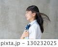 髪を風になびかせ教材を持つ女子学生の横顔 130232025