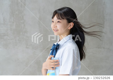 教材を持って爽やかに微笑む女子学生 130232026