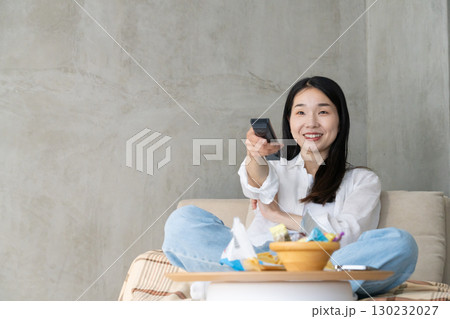 ソファでテレビを楽しむ大人の女性 130232027