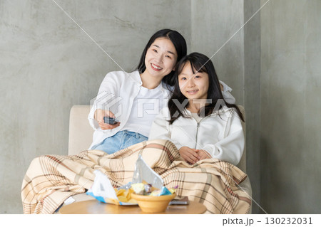 ブランケットに包まれテレビを楽しむ親子 130232031