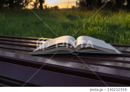 open book resting on bench in grassy area...の写真素材 [130232359] - PIXTA