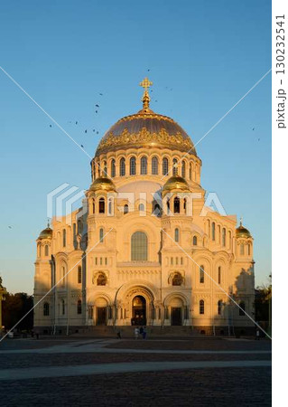 A stunning cathedral stands majestically at sunset, crowned with a beautiful golden dome 130232541