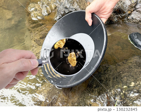砂金採り　採れた砂金を虫メガネでクローズアップ 130232845