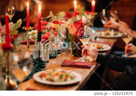 Elegant candlelit dinner with wine and gourmet salad at festive celebration table 130232974