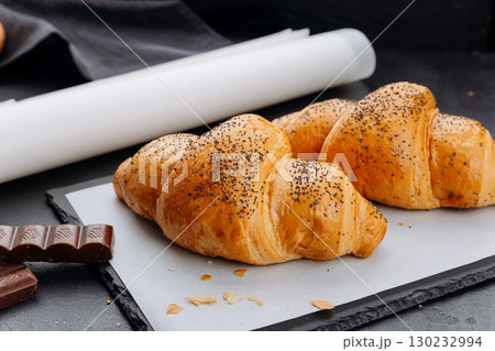 Freshly baked croissants with poppy seeds and chocolate on slate and parchment paper Freshly baked croissants with poppy seeds and chocolate on slate and parchment paper 130232994