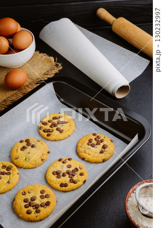 Golden brown chocolate chip cookies cooling on tray, perfect homemade sweet snack 130232997