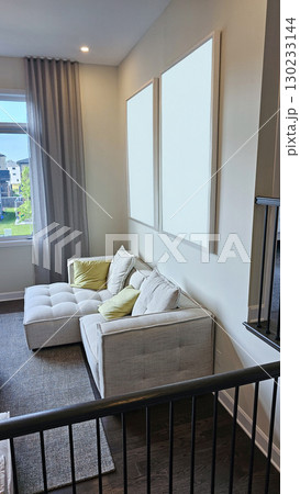 Cozy mockup living room corner featuring a modern sectional sofa with decorative pillows and empty frames on the wall, ideal for interior design inspiration 130233144
