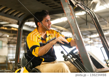 Factory worker operating a forklift inside an industrial warehouse without wearing a safety helmet, illustrating risky behavior, lack of compliance, and workplace safety issues in logistics Factory worker operating a forklift inside an industrial warehouse without wearing a safety helmet, illustrating risky behavior, lack of compliance, and workplace safety issues in logistics 130234498