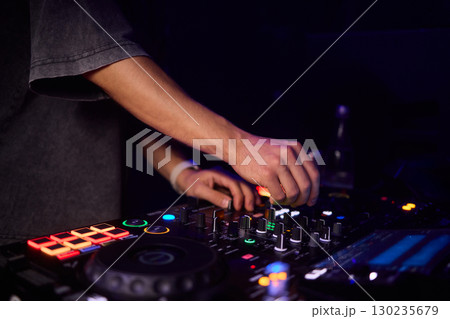 Witness the DJ mixing equipment performing live and in action at a vibrant music event Witness the DJ mixing equipment performing live and in action at a vibrant music event 130235679