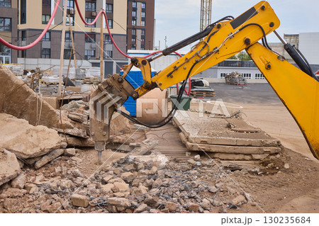 A bustling construction site filled with heavy machinery and ongoing demolition work 130235684