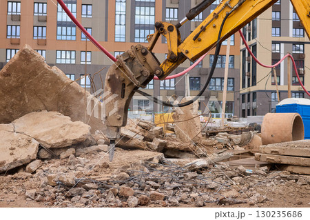 A bustling construction site filled with heavy machinery and ongoing demolition work A bustling construction site filled with heavy machinery and ongoing demolition work 130235686