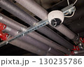 Surveillance Camera Placed in an Industrial Setting Surrounded by Various Pipes and Equipment 130235786