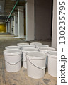 A Collection of Various White Buckets Displayed in a Neat Indoor Setting for Use 130235795