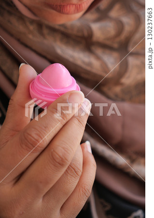 Women holding pink lip bum Women holding pink lip bum 130237663