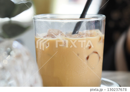 Iced late served in a glass with a straw indoors Iced late served in a glass with a straw indoors 130237678