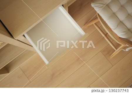 Open drawer in a minimalist workspace with wooden furniture 130237743