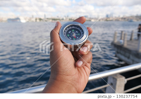 Exploring the waterfront with a compass in hand Exploring the waterfront with a compass in hand 130237754