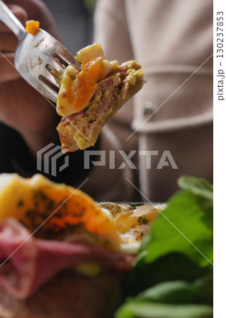 Close-Up of Fork Holding Tasty Food with Fresh Herbs and Greens 130237853