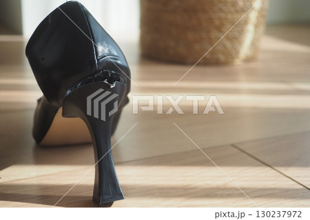 Close-Up of a Worn Black High Heel Shoe Damaged at the Heel 130237972