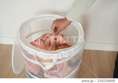 Organizing laundry in a mesh basket at home Organizing laundry in a mesh basket at home 130238000