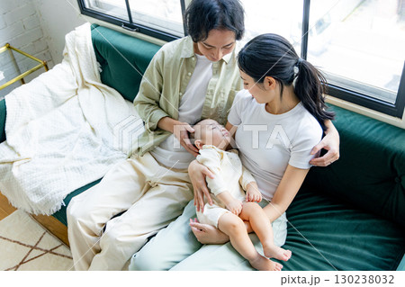 赤ちゃんを抱く若い夫婦 130238032