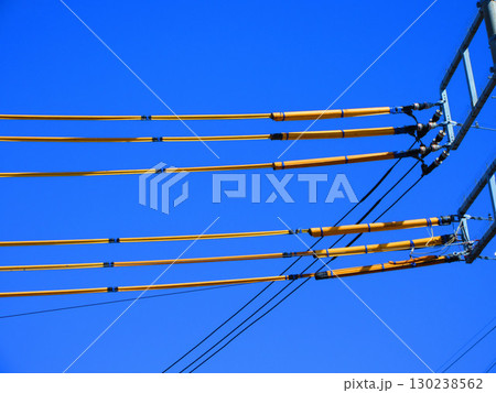 黄色の漏電防止保護カバーが巻かれた電線と青空の風景 130238562